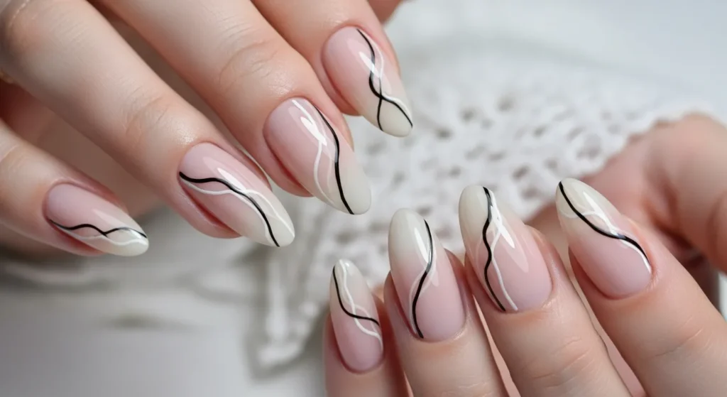 The Cutest Nail Designs June 2025 You’ll Love All Summer 6 Minimalist black and white line art on almond-shaped nails with nude and pastel pink bases.